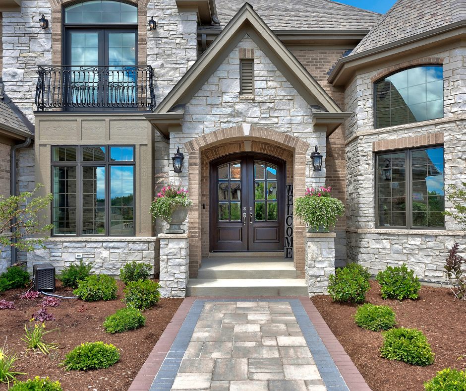 Stone veneer luxury home entrance with arched double doors
