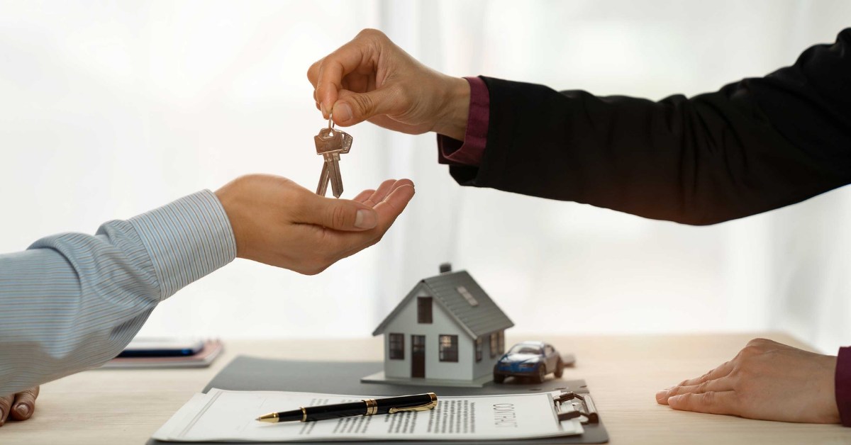 Keys to a new home being handed over across a signed purchase contract